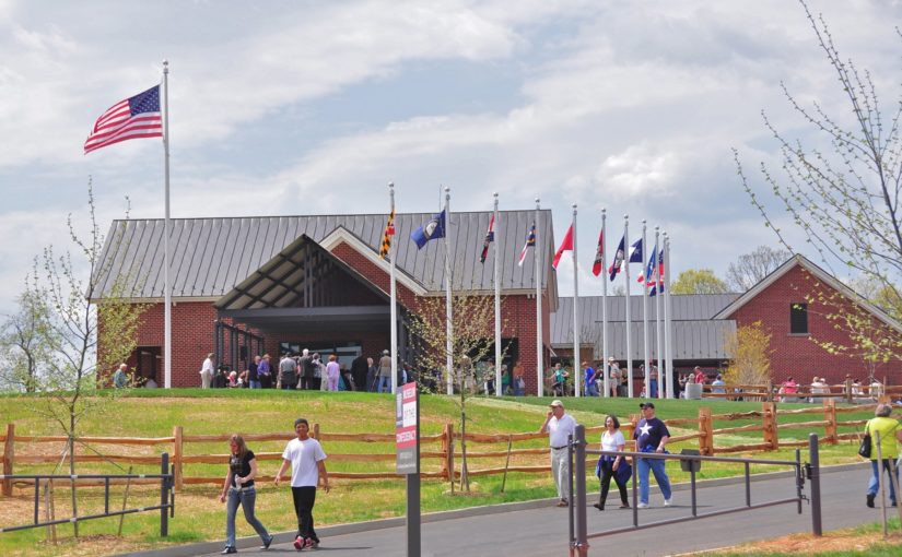 people walking on path with brick building and flags