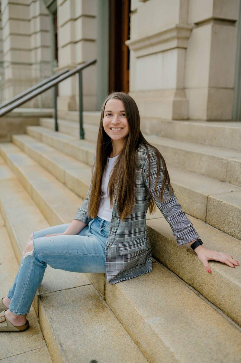 Woman in blazer sitting on concrete steps