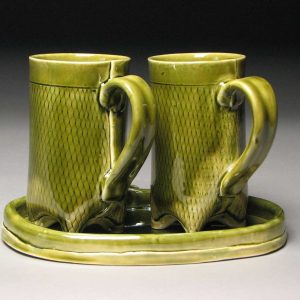 2 green pottery mugs on tray