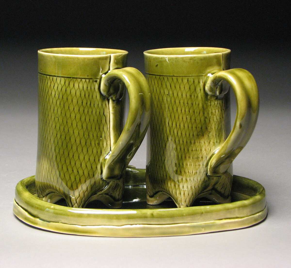 2 green pottery mugs on tray