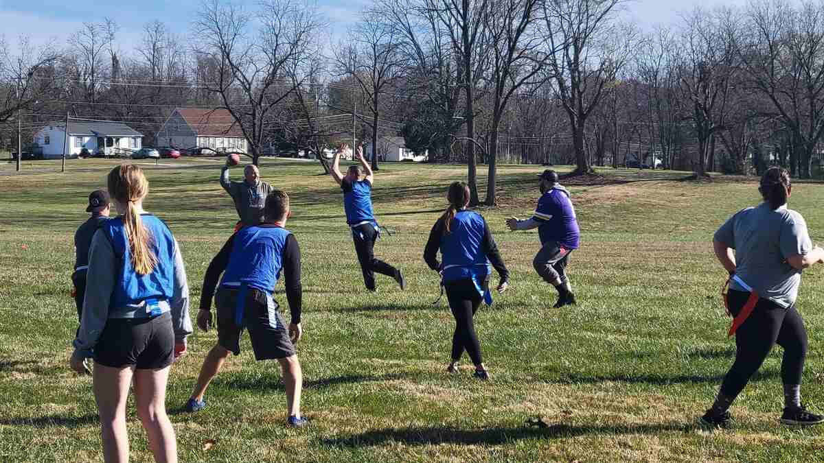 Group of people playing football in field
