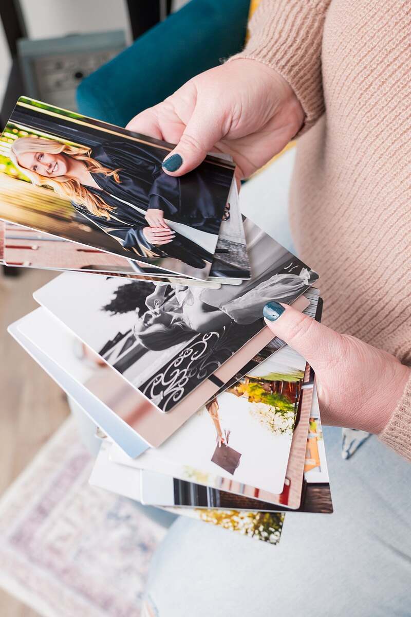 hands holding several photos