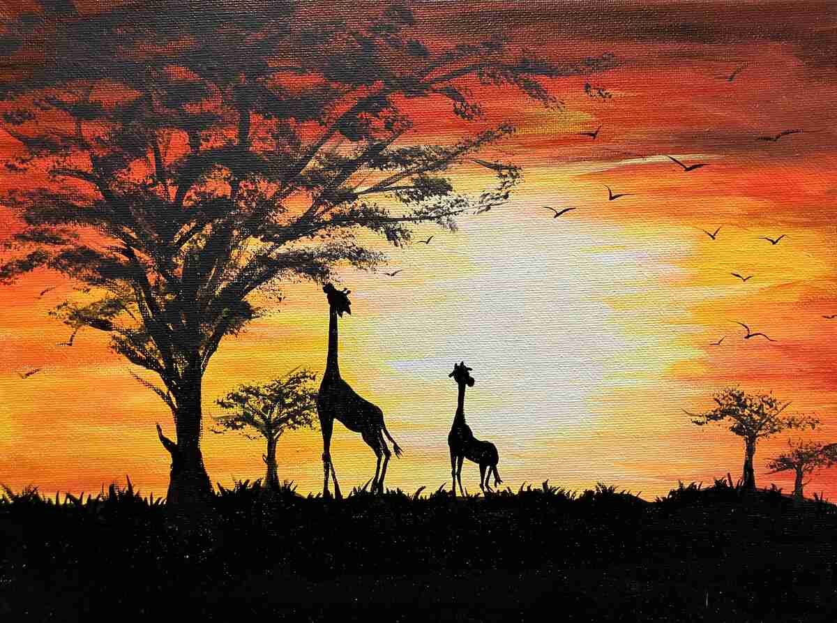 Giraffes and tree in silhouette