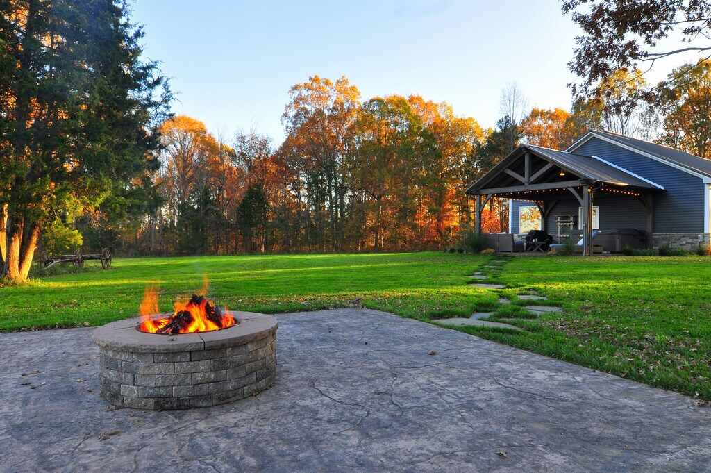 Stone firepit with fire and trees in autumn