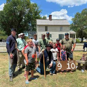 Group of people with old score sign, some wearing civil war uniforms.
