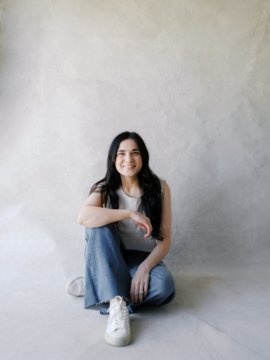Woman with long dark hair sitting on floor