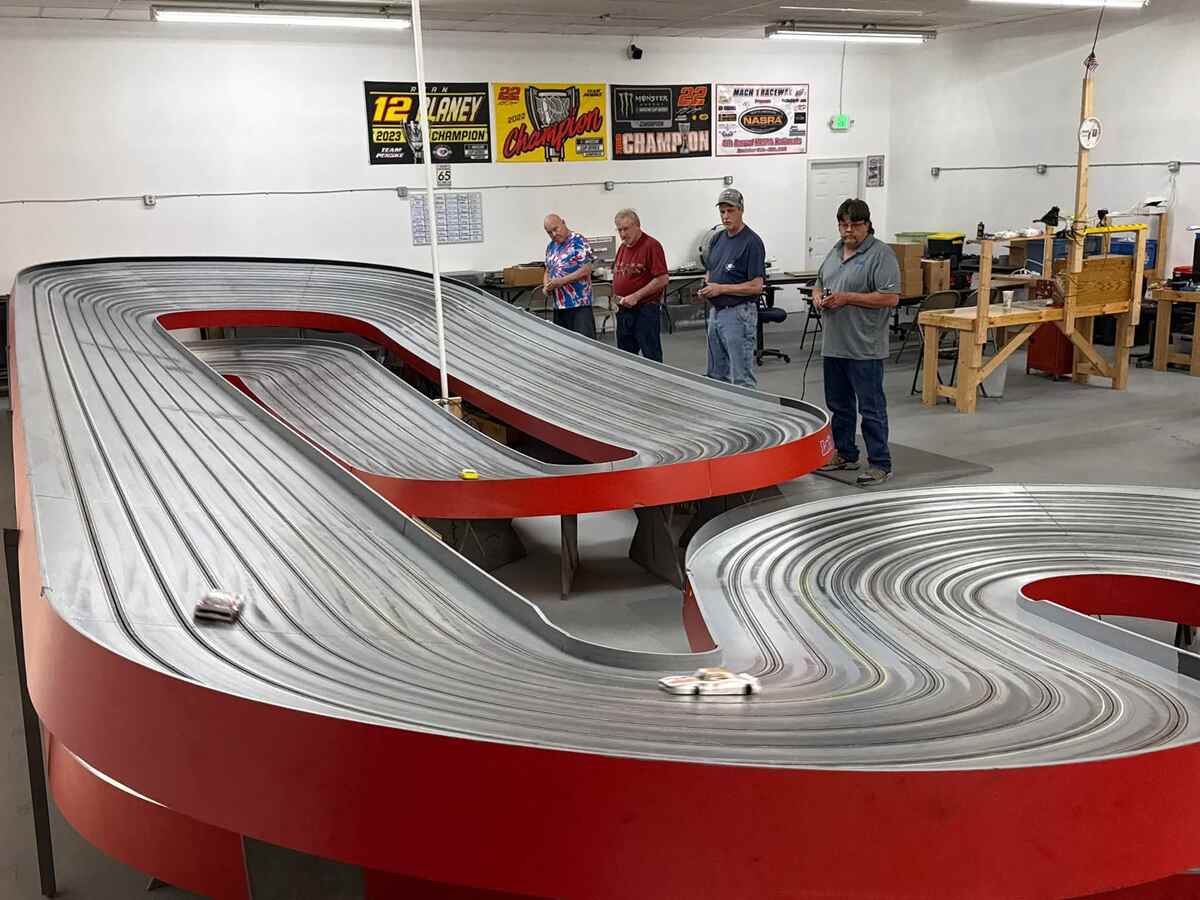 Toy racecar track with four men.