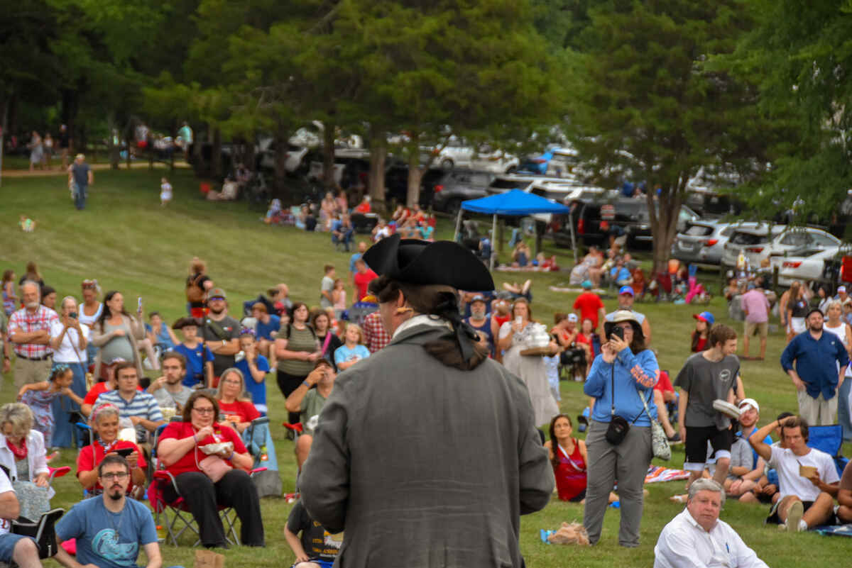 Spectators outside listening to performer in period costume