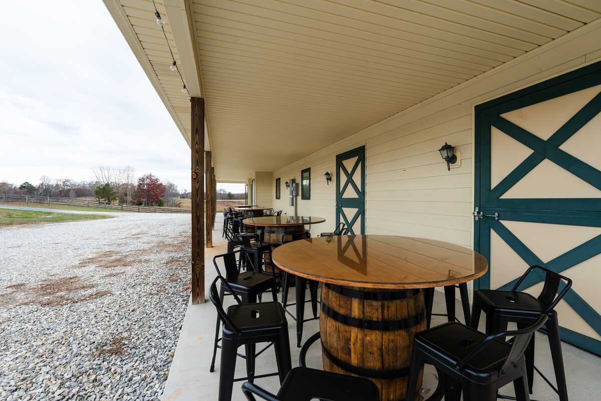 Tables made from barrels and black chairs on porch