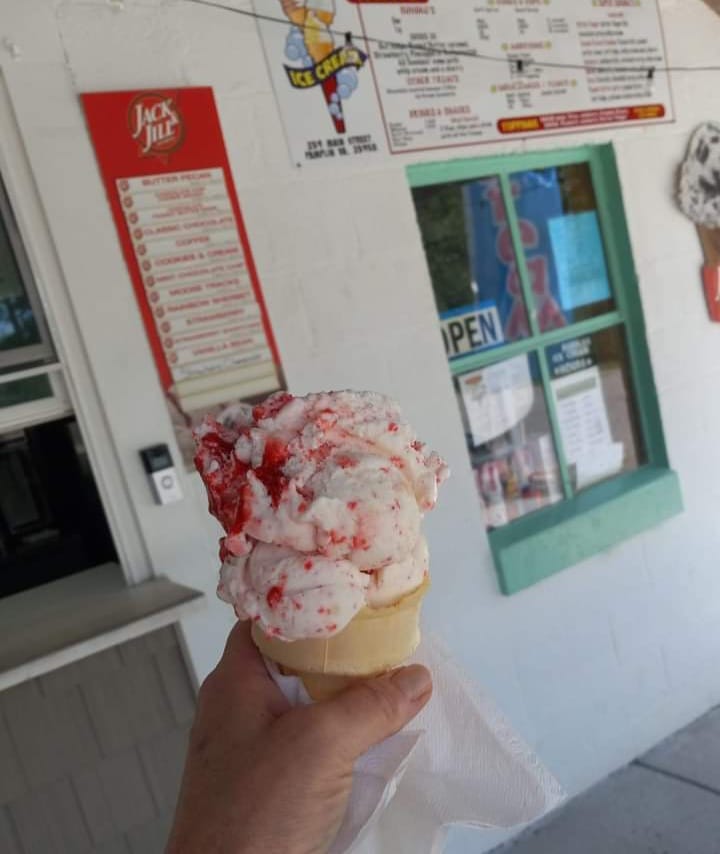 hand holding ice cream cone in front of order window