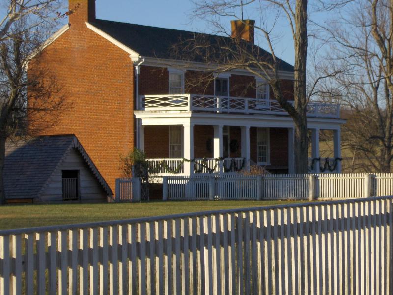 brick house with balconies and picket fence