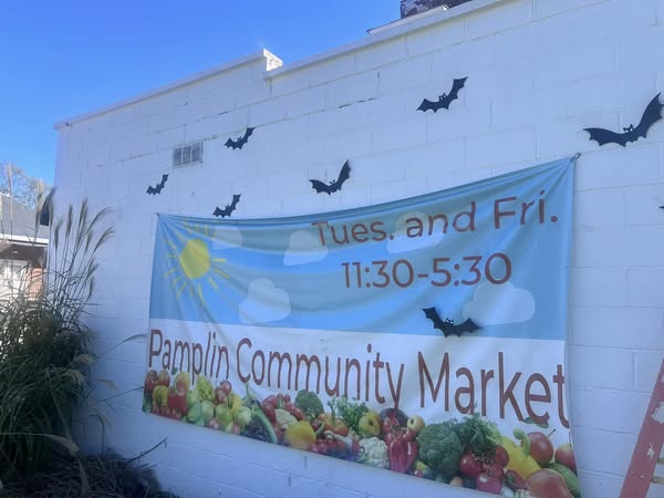 banner on wall with hours of pamplin community market